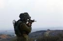 Israeli soldier holds up his weapon outside the northern Gaza Strip