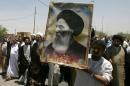 Iraqis carry a poster of top Shi'ite cleric Grand Ayatollah Ali al-Sistani during a demonstration in Najaf