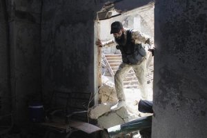 A Free Syrian Army fighter enters his safe house in …