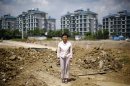 Xu poses at a construction site area where her house stood in Wuxi