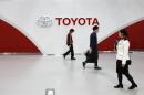 Employees and customer walk in front of Toyota Motor's logo at the company's showroom in Tokyo