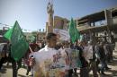 Palestinian demonstrators hold Hamas flags and posters during a rally in Beit Hanun in the northern Gaza Strip on January 30, 2015