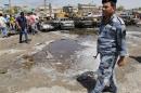 An Iraqi policeman stands guard at the site of a car bomb attack in Sadr City district of Baghdad