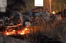 The burnt wreckage of a minivan, which was crushed and caught fire in Sunday's accident, is moved on a transporter out of the Sasago Tunnel on the Chuo Expressway in Koshu, Yamanashi Prefecture, central Japan, early Monday, Dec. 3, 2012. Concrete ceiling panels fell onto moving vehicles deep inside the tunnel, and authorities confirmed nine deaths before suspending rescue work Monday while the roof was being reinforced to prevent more collapses. (AP Photo/Kyodo News) JAPAN OUT, MANDATORY CREDIT, NO LICENSING IN CHINA, FRANCE, HONG KONG, JAPAN AND SOUTH KOREA