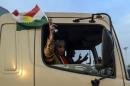 A peshmerga fighter waves a Kurdistan flag as his convoy arrives in Viransehir, in Turkey's Sanliurfa on October 29, 2014, bound for Kobane