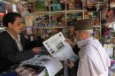 A man buys Ensaf newspaper at a kiosk in Kabul