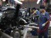An employee works on a car engine along a Geely Automobile Corporation assembly line in Cixi