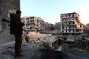 A rebel fighter stands in a building overlooking the damage from fighting in the city of Aleppo on December 16, 2013