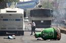 Protester throws stones at police vehicles in the Kurdish dominated southeastern city of Diyarbakir, Turkey
