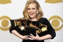 FILE - This is a Sunday, Feb. 12, 2012 file photo of Adele as she poses backstage with her six awards at the 54th annual Grammy Awards on Sunday, Feb. 12, 2012 in Los Angeles. Adele won awards for best pop solo performance for "Someone Like You," song of the year, record of the year, and best short form music video for "Rolling in the Deep," and album of the year and best pop vocal album for "21." Adele is getting a new medal to go alongside her Grammys and Academy Award _ an honor from Queen Elizabeth II. The "Rumor Has It" and "Skyfall" singer was named a Member of the Order of the British Empire, or MBE on Friday June 14, 2013 in the queen's annual Birthday Honors list. (AP Photo/Mark J. Terrill, File)
