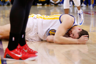 Klay Thompson lays on the court after being kneed in the head. (Ezra Shaw/Getty Images)
