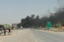 Smoke billows from a Iraqi police checkpoint following two bomb attacks on June 9, 2014, in northern town of Tuz Khurmatu