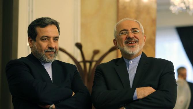 Iran's chief nuclear negotiator Abbas Araghchi (L) and Foreign Minister Javad Zarif listen to President Hassan Rouhani (unseen) speaking during a press conference in Tehran on April 3, 2015