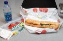 FILE - This Aug. 11, 2009, file photo, shows a chicken breast sandwich and water from subway on a kitchen counter in New York. Subway, the world's largest fast food chain, is facing criticism after an Australian man posted a picture on the company's Facebook page on Jan. 16, 2013, of one of its famous sandwiches next to a tape measure that seems to shows it's not as long as promised. (AP Photo/Seth Wenig, File)