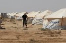 A Jordanian worker walks among the tents at the Zaatari Camp