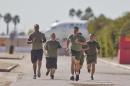 In a Thursday, Oct. 17, 2013 photo, a group of sailors and Marines who failed the so-called "tape test'' are led by an instructor on a three mile run as they work to improve their fitness and remain in the military, at the Marine Corps Recruit Depot in San Diego. Doctors say a number of military personnel are turning to liposuction to remove excess fat from around the waist so they can pass the Pentagon's body fat test. Some service members say they have no other choice because the Defense Department's method of estimating body fat is weeding out not just flabby physiques but bulkier, muscular builds. A number of fitness experts and doctors agree, and they're calling for the military's fitness standards to be revamped. (AP Photo/Lenny Ignelzi)