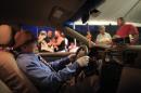 The body of Victor Perez Cardona is propped up inside his taxi during his wake in Aguas Buenas, Puerto Rico, Sunday, May 24, 2015. Perez Cardona, 73, a cancer patient and a veteran taxi driver known in the town of Aguas Buenas as 'Vitín the driver', joined the unusual tradition of wakes to honor his profession being veiled as if he were driving his taxi. (AP Photo/Ricardo Arduengo)