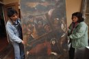 In this Aug. 21, 2013 file photo, workers from the Culture Ministry display a recovered 18th century painting by an anonymous artist depicting Jesus in La Paz, Bolivia. This painting titled "Jesus con la Cruz a Cuesta" was stolen from the San Pedro de la Paz church in Bolivia on June 11, 2003, and recovered in the Peruvian capital of Lima in April 2005. Increasingly bold thefts plague colonial churches in remote Andean towns in Bolivia and Peru, where religious and civil authorities say cultural treasures are disappearing at an alarming rate. (AP Photo/Juan Karita)