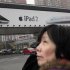 File photo of a woman standing near an Apple billboard advertising the iPad 2 in downtown Shanghai