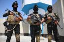 Iraqi security forces stand guard at the entrance to Basra on July 10, 2014