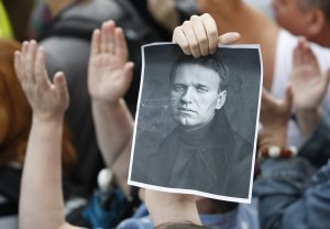 People hold a poster of opposition figure Alexei Navalny …