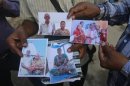 Relatives of missing people, affected by the flash floods and landslides, display their photographs outside the Indian Air Force base in Dehradun