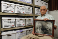 Jack Goins poses with a photo dated to have been taken in 1898 of his   step-great-great grandfather George Washington Goins, who died in 1817, left, and great-great grandmother, Susan Minor-Goins who died in 1813 at the Hawkins County Archives Project building Wednesday, May 23, 2012 in Rogersville, Tenn. Goins is of Melungeon descent and has researched Melungeon history for around 40 years. A new DNA study in the Journal of Genetic Genealogy found that the families historically called Melungeons are the offspring of sub-Saharan African men and white women of northern or central European origin. (AP Photo/Wade Payne)