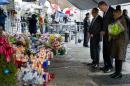 From left, Pastor Michael Durso, New York City Mayor Bill de Blasio and New York City first lady Chirlane McCray visit a makeshift memorial Tuesday, Dec. 23, 2014, near the site where New York Police Department officers Rafael Ramos and Wenjian Liu were shot and killed in the Brooklyn borough of New York. Police say Ismaaiyl Brinsley ambushed the two officers in their patrol car in broad daylight Saturday, fatally shooting them before killing himself inside a subway station. (AP Photo/Craig Ruttle)