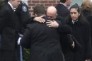 Mourners hug as they depart St. Patrick's Church in Stoneham, Mass., following a funeral Mass for Massachusetts Institute of Technology police officer Sean Collier, Tuesday, April 23, 2013. Collier was fatally shot on the MIT campus Thursday, April 18, 2013. Authorities allege that the Boston Marathon bombing suspects were responsible. (AP Photo/Steven Senne)