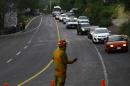 A firefighter helps control traffic on the Guadalajara - Autlan highway in Jalisco state, Mexico, on May 1, 2015