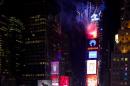 Looking from the Marriott Marquis hotel, fireworks erupt from One Times Square as the Waterford Crystal ball that will mark the new year is raised into position at six hours before midnight for New Year's Eve celebrations in New York Tuesday, Dec. 31, 2013. (AP Photo/Craig Ruttle)