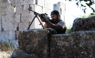 This citizen journalism image provided by Shaam News Network SNN, taken on Monday, July 4, 2012, purports to show a Free Syrian Army soldier aiming his weapon in the northern town of Sarmada, in Idlib province, Syria. Syria's military began large-scale exercises simulating defense against outside "aggression," the state-run news agency said Sunday an apparent warning to other countries not to intervene in the country's crisis. (AP Photo/Shaam News Network, SNN)THE ASSOCIATED PRESS IS UNABLE TO INDEPENDENTLY VERIFY THE AUTHENTICITY, CONTENT, LOCATION OR DATE OF THIS HANDOUT PHOTO