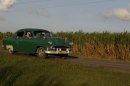In this Sept. 8, 2012 photo, people drive a classic American car past a sugar cane field in Camaguey, Cuba. Just two years ago, Cuba's sugar industry was on its knees after the worst harvest in more than a century. Now Cuba's signature industry is showing signs of life. With world market prices rebounding, sugar is suddenly more profitable, and a reorganization of the sector could offer a blueprint for how to lift up the rest of the island's economy. (AP Photo/Franklin Reyes)