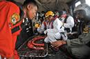 Indonesian rescuers confer on an Air Force NAS 332 Super Puma helicopter during the search operation for the victims and the wreckage of AirAsia Flight 8501 over the Java Sea off Pangkalan Bun, Central Borneo, Indonesia, Tuesday, Jan. 6, 2015. The Singapore-bound plane crashed into the sea 42 minutes after taking off on Dec. 28. (AP Photo/Veri Sanovri, Pool)