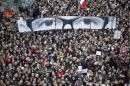 File picture of people holding panels to create an image depicting the eyes of Charb at a solidarity march in the streets of Paris