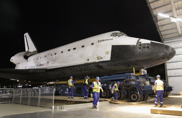 Members of a work crew guide the retired Space Shuttle Endeavour as it enters a hanger at the California Science Center October 14, 2012. Endeavour rolled into its retirement home at the Center early on Sunday, in the conclusion of a slow-motion parade through the narrow streets of Los Angeles. REUTERS/Lawrence K. Ho/Los Angeles Times/Pool (UNITED STATES - Tags: SCIENCE TECHNOLOGY SOCIETY)