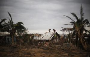 Fishermen and their family members repair the roof of their houses at the cyclone-hit Nalianuagaon village