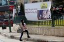 FILE PHOTO: A Palestinian woman walks past a banner against a promise by U.S. President-elect Trump to relocate the U.S. embassy to Jerusalem, in the West Bank city of Nablus