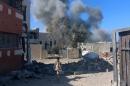 Fighter of Libyan forces allied with the U.N.-backed government walks as smokes rises following an air strike on Islamic State positions in Ghiza Bahriya district in Sirte