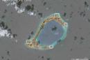 A satellite image shows what CSIS Asia Maritime Transparency Initiative says appears to be anti-aircraft guns and what are likely to be close-in weapons systems (CIWS) on the artificial island Subi Reef in the South China Sea