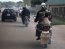 A woman commutes on a motorcycle taxi with her child wrapped on her back in Nigeria's northern city of Kaduna