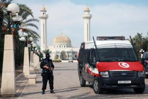 A Tunisian security guard stands near a police vehicle …