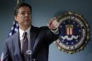 FBI Director James Comey takes a question from reporter during a news conference at the FBI office in Boston