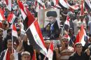 Demonstrator holds a picture of Shi'ite cleric Moqtada al-Sadr during a protest in Baghdad