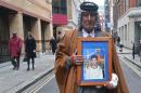 Mizal Karim Al-Sweady holds a photograph of his dead son Hamid Al-Sweady after giving evidence to the Al-Sweady Inquiry in London