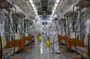 Workers in full protective gear disinfect the interior of a subway train at a Seoul Metro's railway vehicle base in Goyang