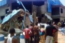 Bystanders look at the Sharon Church after it was struck by a suicide bomber's attack in Kaduna