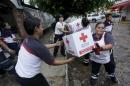 Red Cross volunteers load humanitarian aid boxes from a truck in the Pacific beach resort of Puerto Vallarta