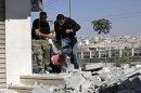 Free Syrian Army fighters try to drag a civilian's body to a safe side after being shot by a sniper loyal to Syria's President Bashar al-Assad, in Aleppo's district of al-Midan