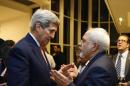 U.S. Secretary of State John Kerry talks with Iranian Foreign Minister Mohammad Javad Zarif, right, after the International Atomic Energy Agency (IAEA) verified that Iran has met all conditions under the nuclear deal, in Vienna, Saturday Jan. 16, 2016. (Kevin Lamarque/Pool via AP)